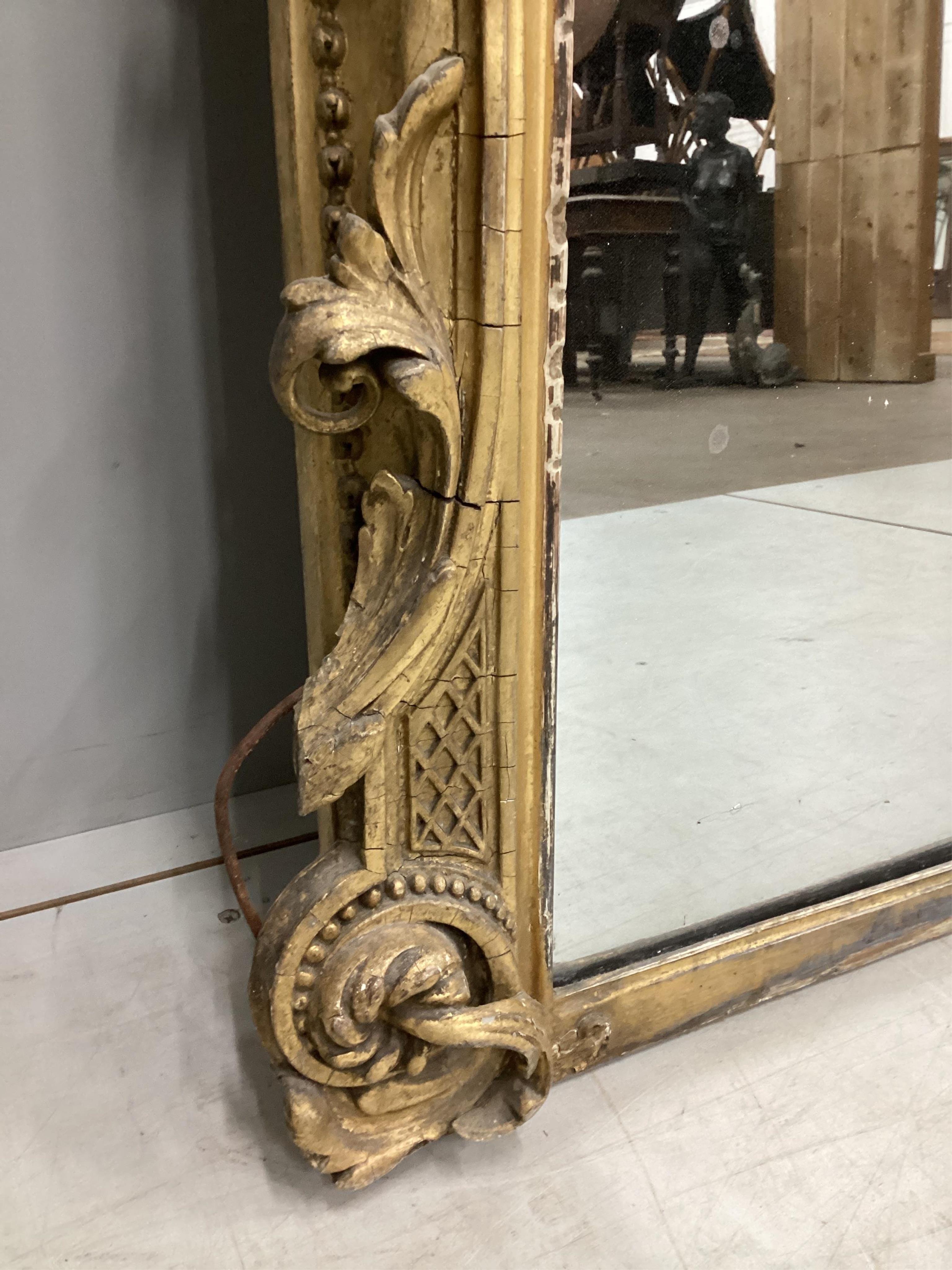 A Victorian giltwood and composition overmantel mirror with cartouche pediment, width 140cm, height 201cm. Condition - fair, three areas of lost gesso